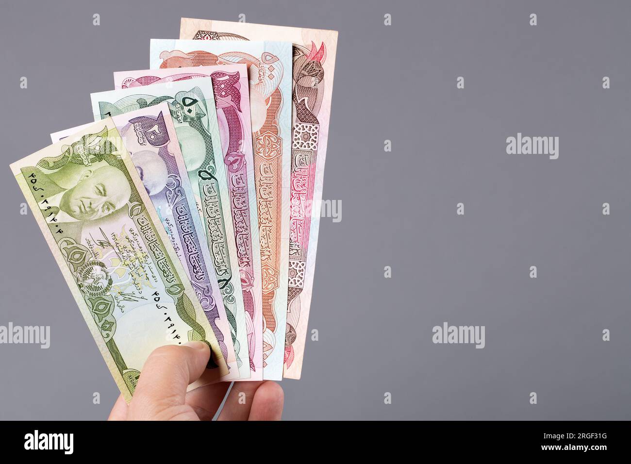 Afghanisches Geld - afghani in der Hand auf grauem Hintergrund Stockfoto