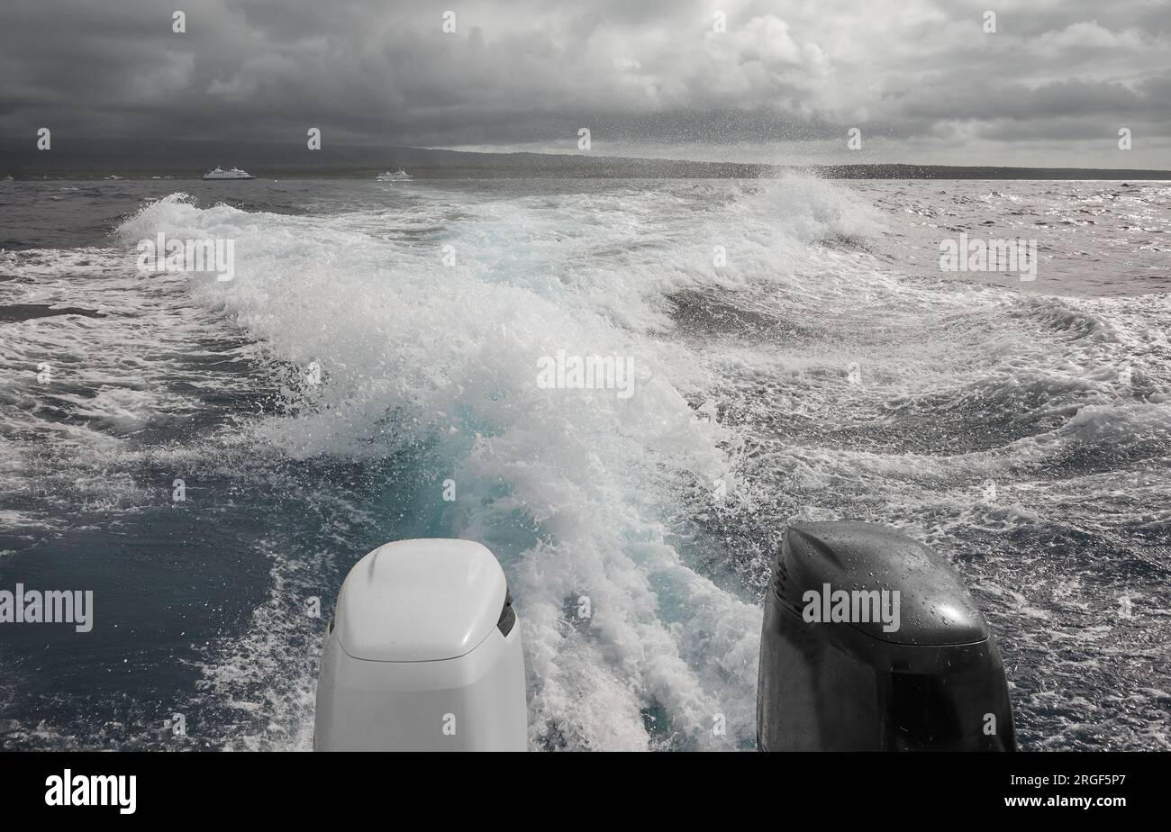 Leistungsstarke Außenbordmotoren eines Schnellboots, das vor einem Sturm flieht, selektiver Fokus. Stockfoto