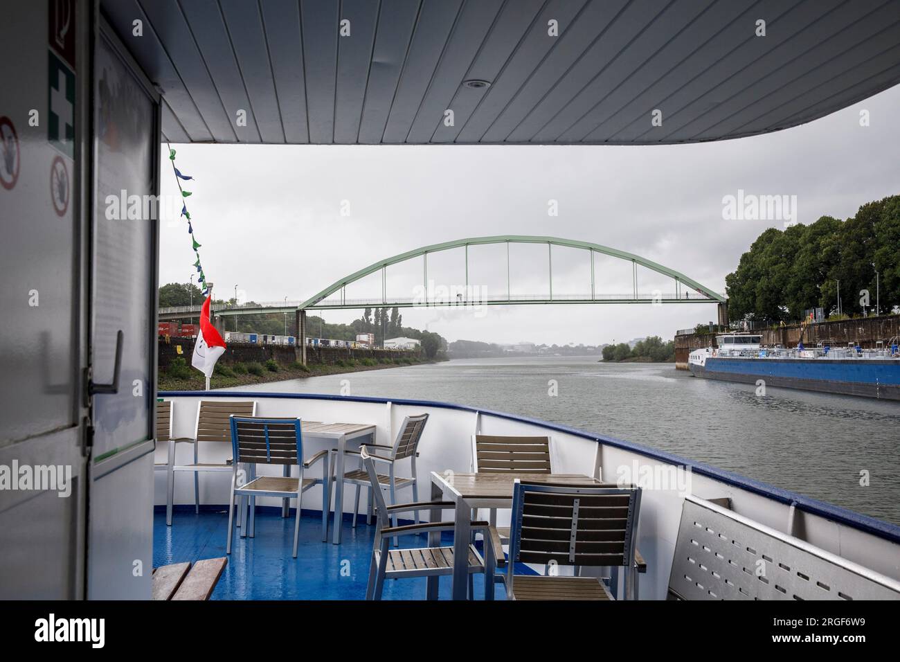 Blick von einem Ausflugsschiff auf die Brücke für Fußgänger und Radfahrer im Hafen von Niehler, Regen, Köln, Deutschland. Blick von einem Ausflugsschiff zur Stockfoto