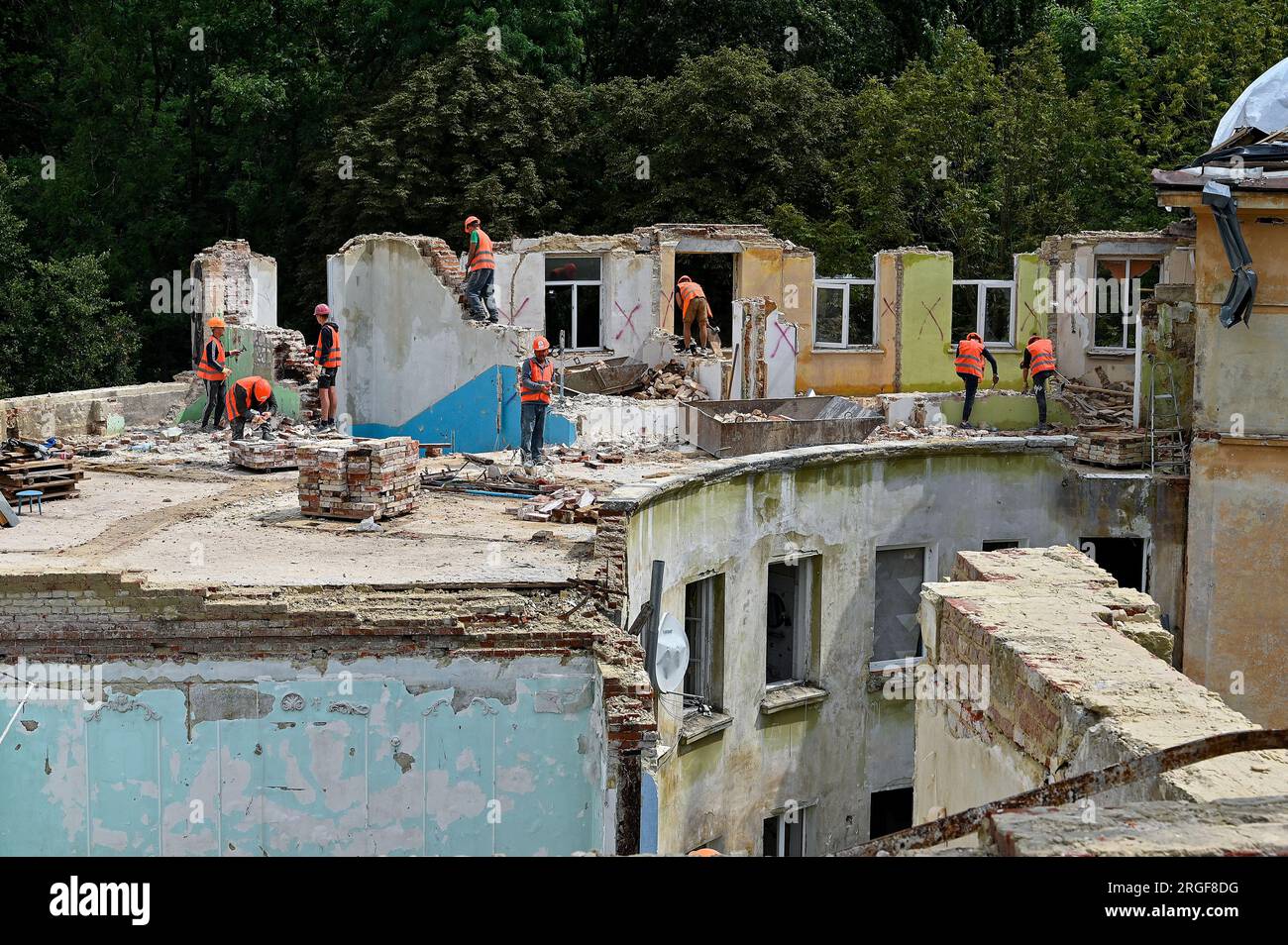 LEMBERG, UKRAINE - 8. AUGUST 2023 - Bauarbeiter führen Abbrucharbeiten im Rahmen des Umbaus des Wohnungsgebäudes zum Teil rui durch Stockfoto