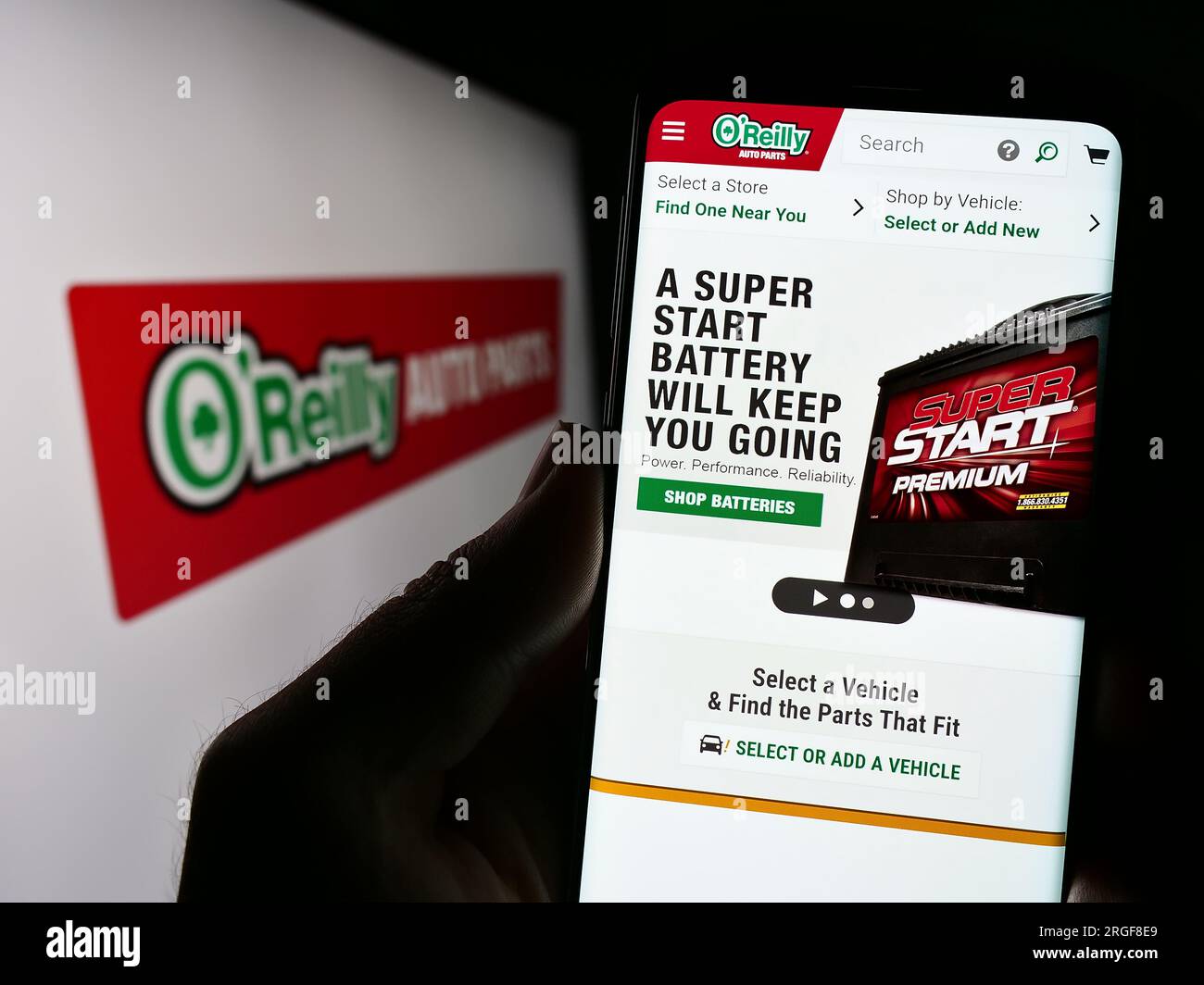 Person, die ein Mobiltelefon mit einer Webseite des US-amerikanischen Autoteile-Unternehmens O’Reilly Automotive Inc. Auf dem Bildschirm mit Logo hält. Konzentrieren Sie sich auf die Mitte des Telefondisplays. Stockfoto