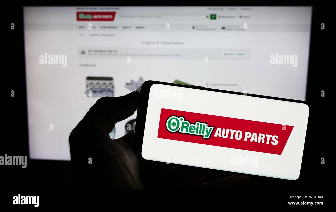 Person, die ein Mobiltelefon mit dem Logo des amerikanischen Autoteile-Unternehmens O’Reilly Automotive Inc. Auf dem Bildschirm vor der Webseite hält. Konzentrieren Sie sich auf das Display des Telefons. Stockfoto