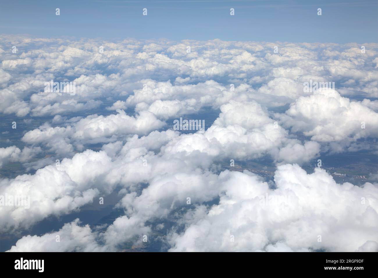 Blick über die Wolken mit Land sichtbar unter dem Flugzeugfenster auf dem Ägäischen Flug nach Griechenland Stockfoto