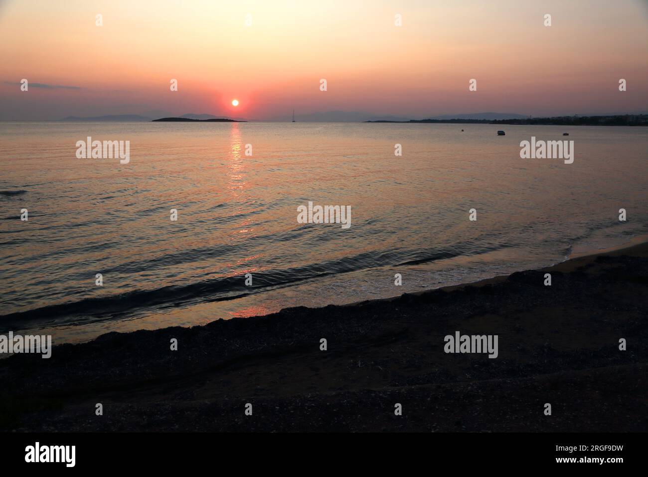 Vouliagmeni Beach Athen Griechenland Sonnenuntergang über dem Meer Stockfoto