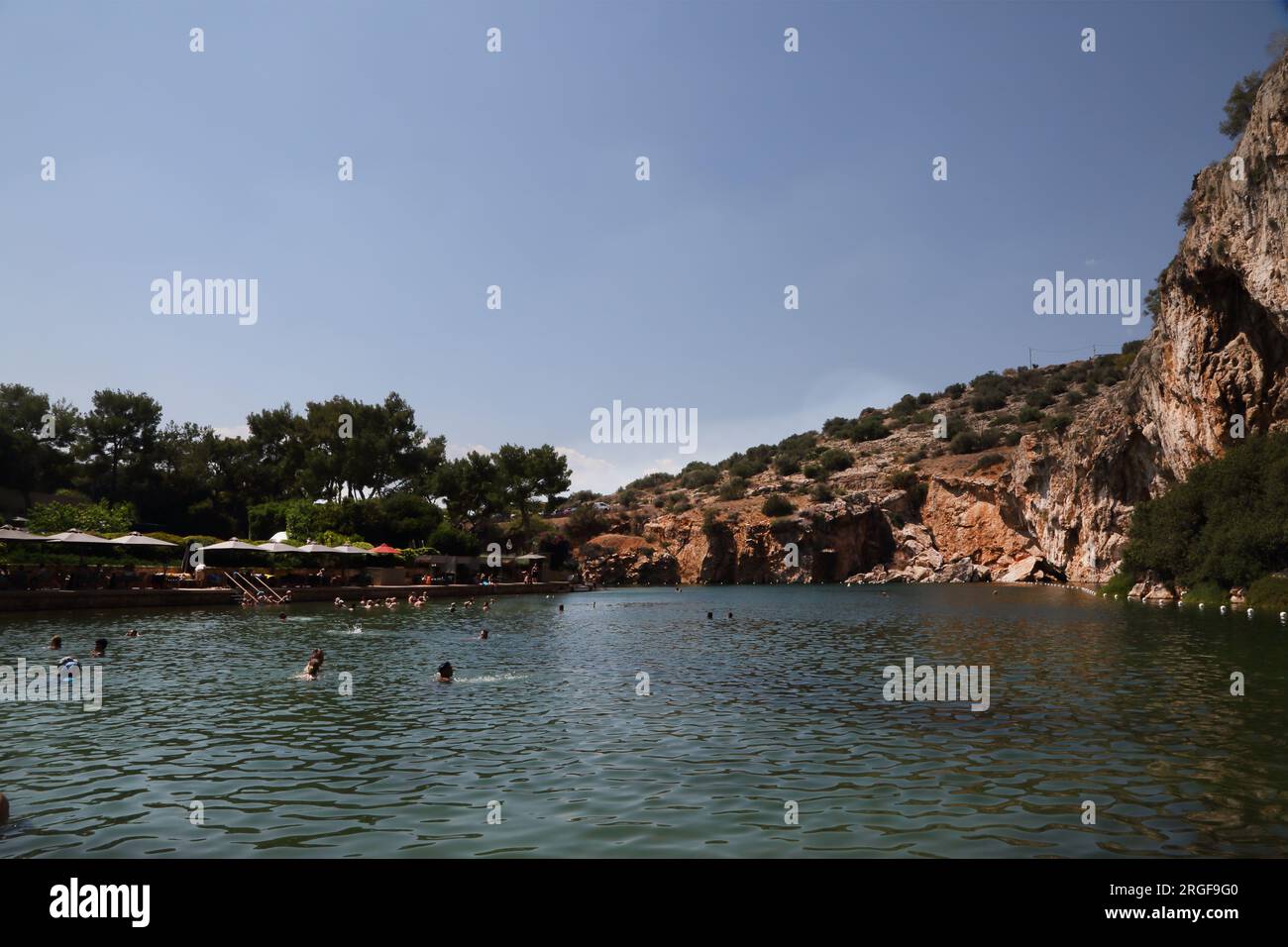 Vouliagmeni Athen griechische Touristen Schwimmen im See Vouliagmeni ein Naturbad - war einst eine Höhle, aber das Höhlendach fiel durch Erosion aus der hinein Stockfoto