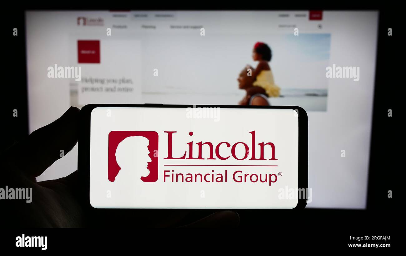 Person, die ein Smartphone mit dem Logo des US-Finanzunternehmens Lincoln National Corporation auf dem Bildschirm vor der Website hält. Konzentrieren Sie sich auf das Display des Telefons. Stockfoto