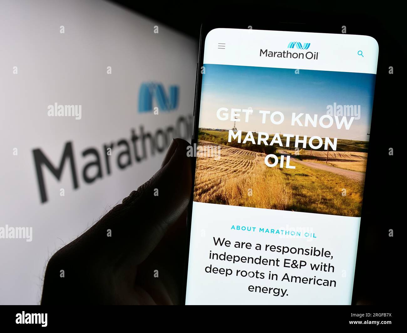 Person, die ein Handy mit einer Website der US-amerikanischen Erdölgesellschaft Marathon Oil Corporation auf dem Bildschirm mit Logo hält. Konzentrieren Sie sich auf die Mitte des Telefondisplays. Stockfoto