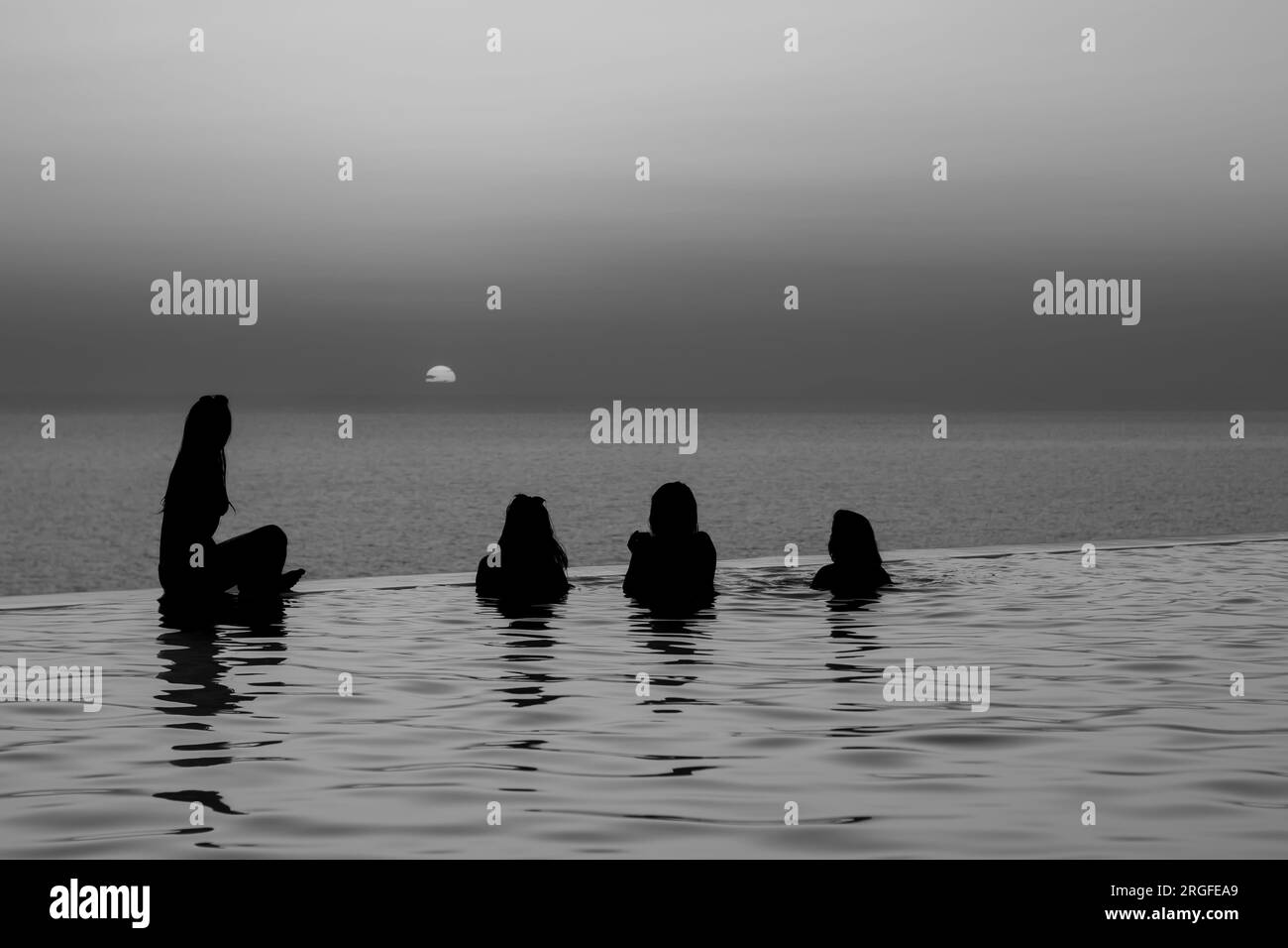 IOS, Griechenland - 17. August 2018 : Freunde in einem Swimmingpool mit Blick auf die Ägäis und beobachten einen atemberaubenden Sonnenuntergang in den iOS kykladen Griechenland Stockfoto