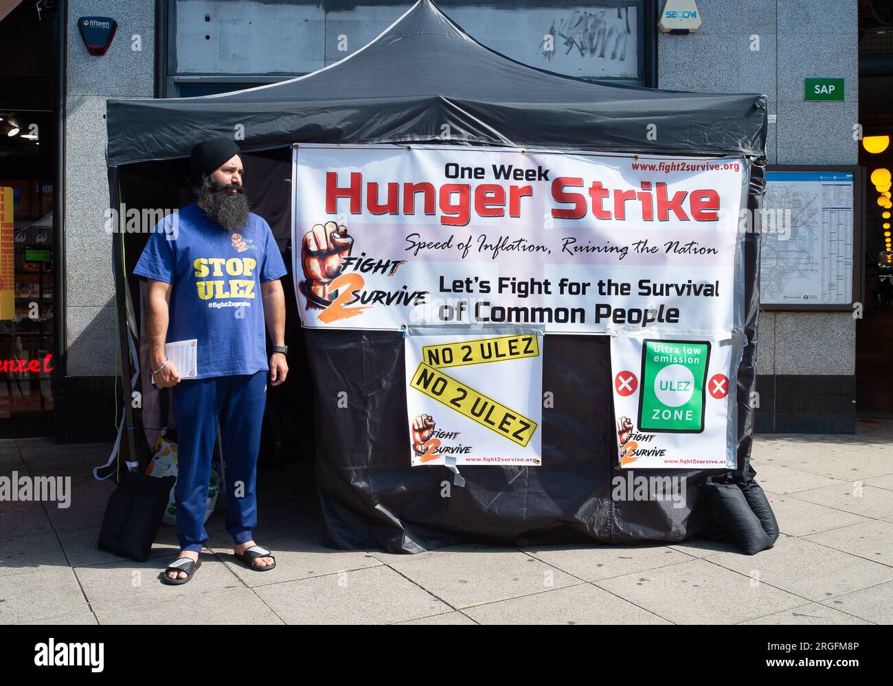 Uxbridge, Großbritannien. 9. August 2023. Der Taxifahrer Prabhdeep Singh ist am 4. Tag eines 7-tägigen Hungerstreiks vor der U-Bahn-Station Uxbridge im Londoner Stadtteil Hillingdon. Er protestiert gegen die neue erweiterte ULEZ (Ultra Low Emission Zone), die Ende dieses Monats in West London in Kraft treten wird. Herr Singh, der an den Stop ULEZ- und Fight2Survive-Kampagnen teilnimmt, ist Taxifahrer aus Reading, der seine Passagiere oft in London Heathrow (LHR) absetzt. Ab Ende August wird LHR nun Teil der erweiterten extrem emissionsarmen Zone sein, die von Transport eingerichtet wird Stockfoto