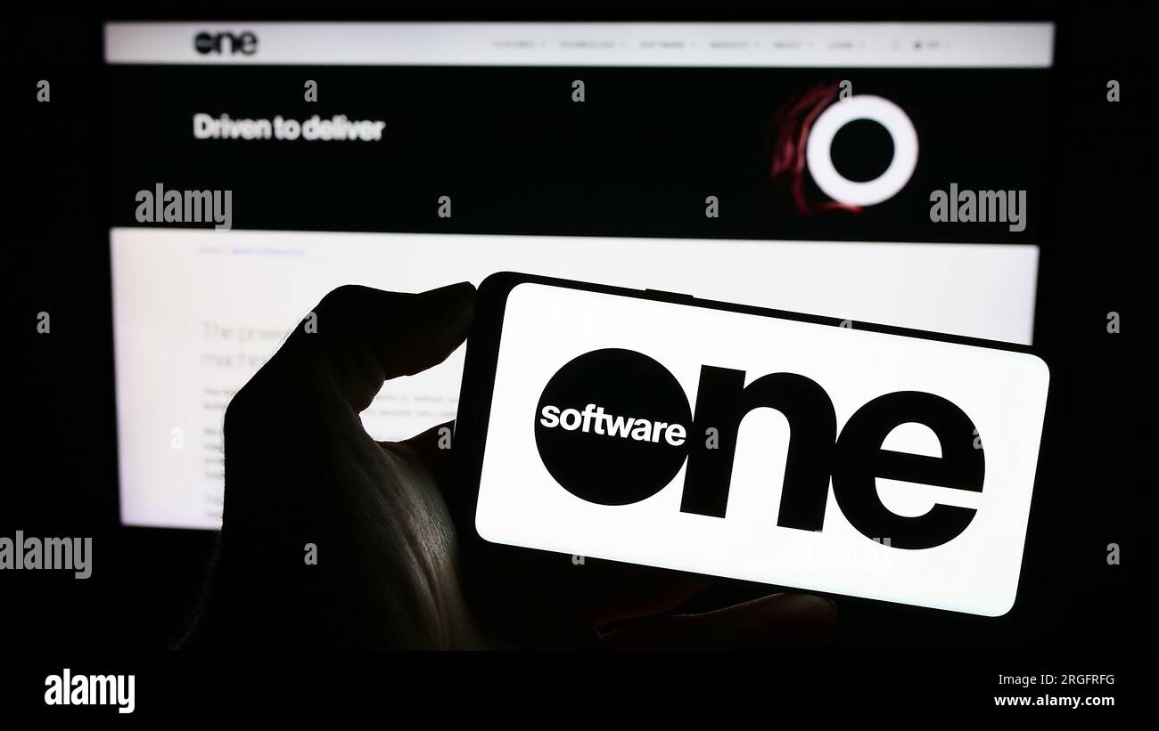 Person, die ein Smartphone mit dem Logo des Schweizer SoftwareOne AG auf dem Bildschirm vor der Website hält. Konzentrieren Sie sich auf das Display des Telefons. Stockfoto