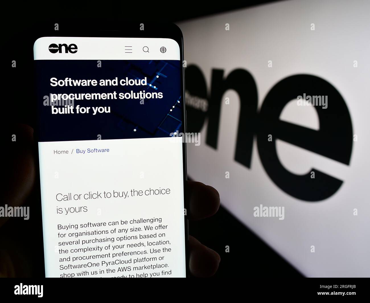 Person, die ein Mobiltelefon hält, mit Webseite des Schweizer SoftwareOne AG auf dem Bildschirm vor dem Logo. Konzentrieren Sie sich auf die Mitte des Telefondisplays. Stockfoto