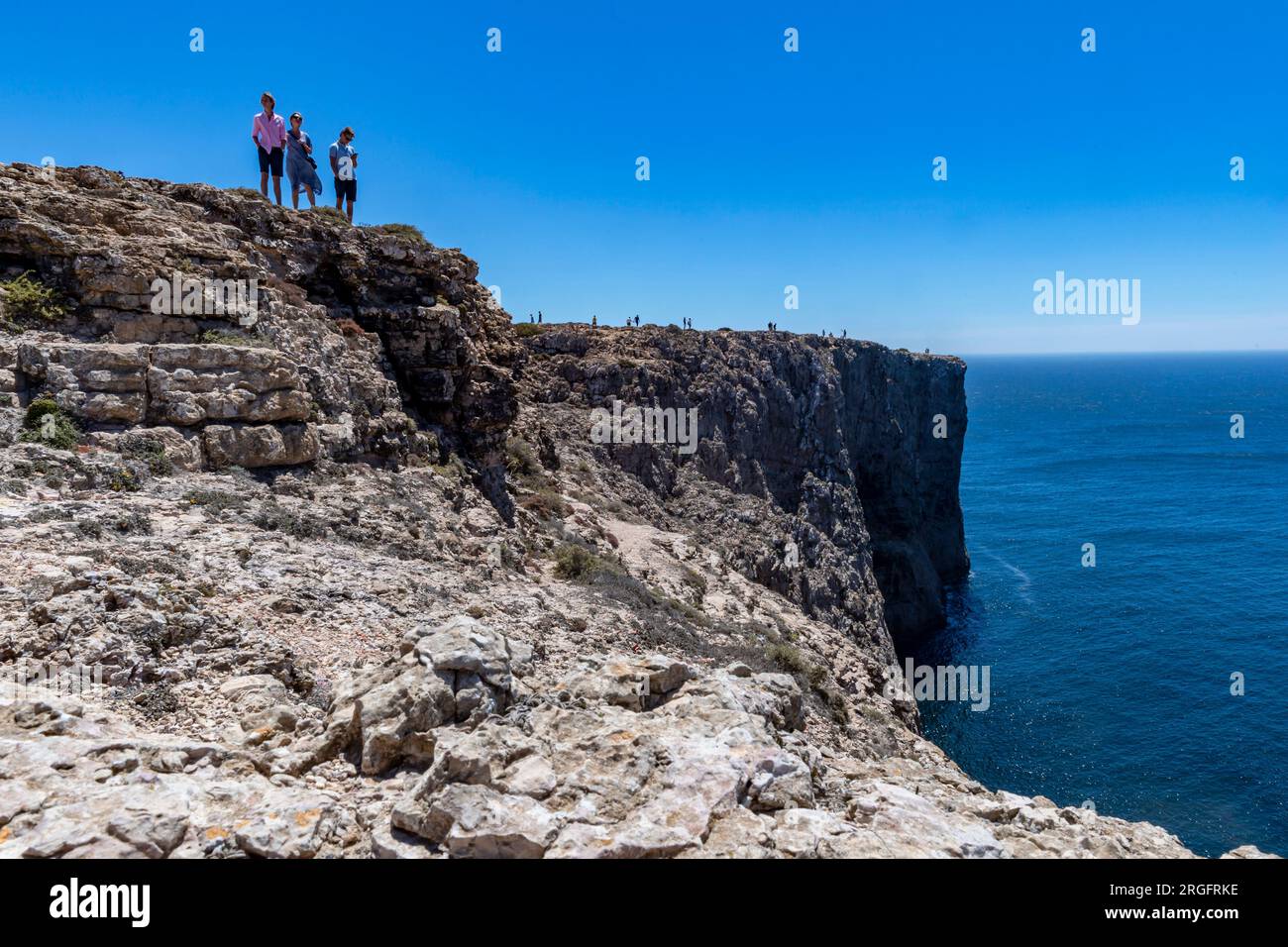 Drei Menschen auf den Felsen über dem Meer Stockfoto