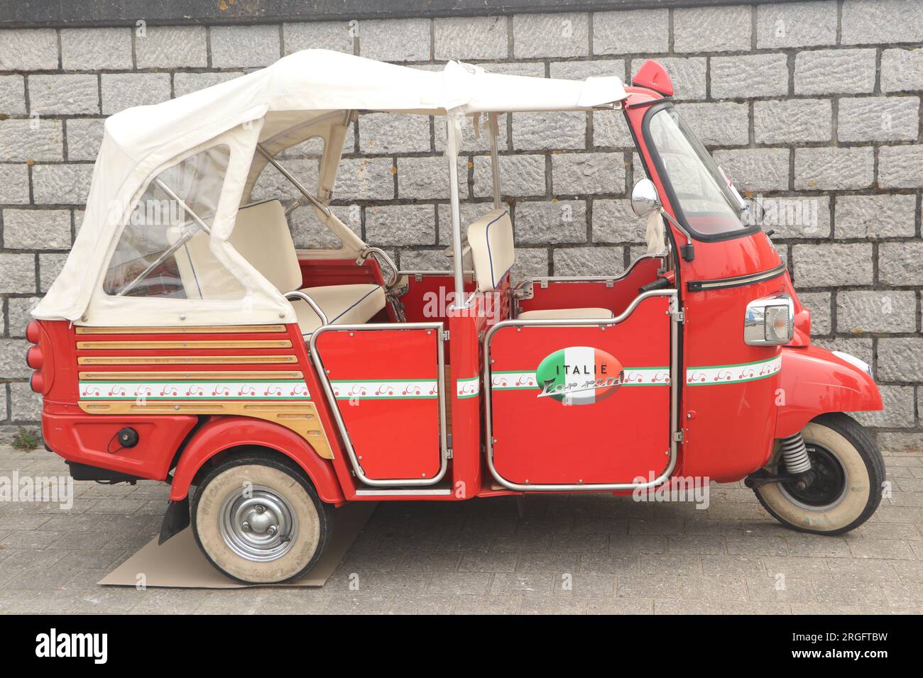 Red Piaggio APE Calessino parkt auf der Straße in Lelystad, Niederlande - Juni 18 2023 Stockfoto