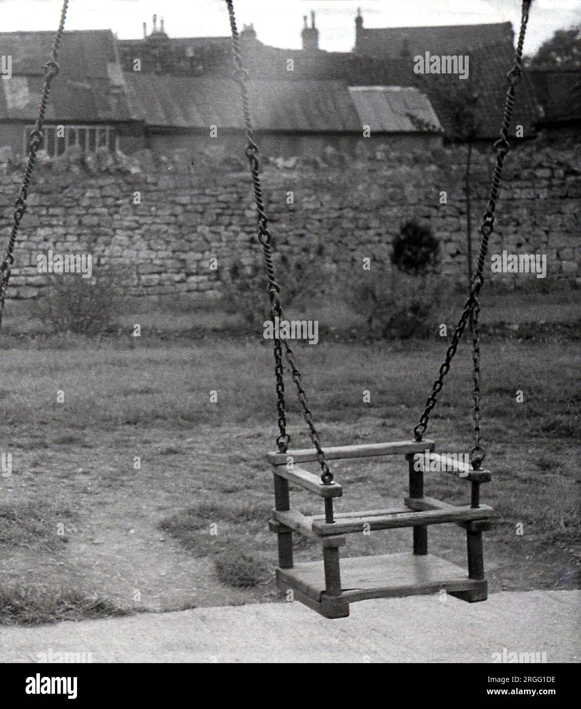 1935, historisch, ein hölzerner Sitz, Kettenschaukel, England, UK. Spielgeräte für Kinder wie Schaukeln wurden in der viktorianischen Ära und darüber hinaus beliebt, da Gesetze sie daran hindern, zu arbeiten, bedeuteten, dass sie mehr Zeit zum Spielen im Freien hatten. Stockfoto