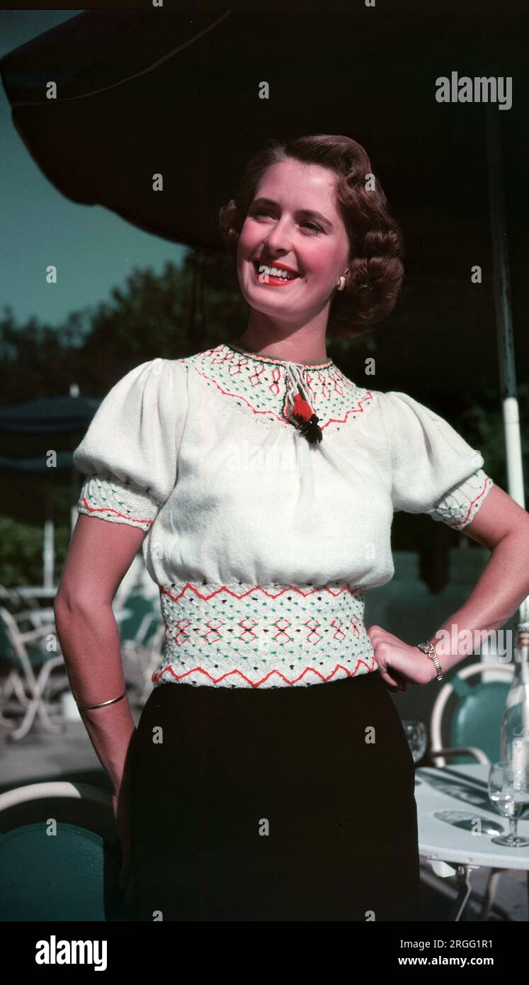 1950er, historisch, Sommer und draußen stehend, eine junge Frau mit kurzen Ärmeln aus Wolle, Rundhalsausschnitt, gemustertes Oberteil der Epoche, England, Großbritannien. Stockfoto