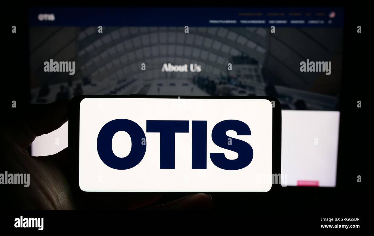 Person, die ein Smartphone mit dem Logo des US-amerikanischen Aufzugsunternehmens Otis Worldwide Corporation auf dem Bildschirm vor der Website hält. Konzentrieren Sie sich auf das Display des Telefons. Stockfoto