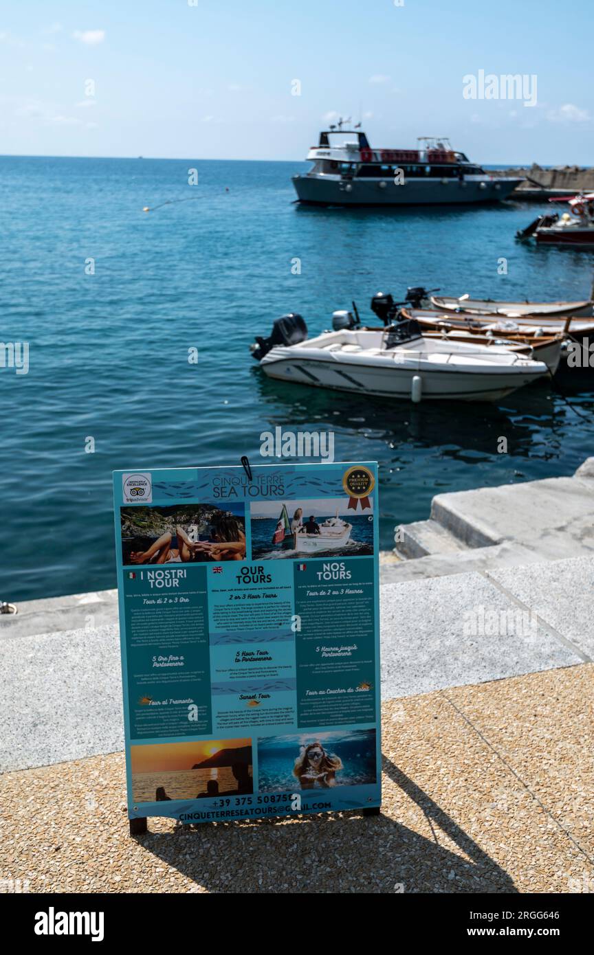 Ein 5 Terre Boat Cruise Tours Schild an der Küste von Monterosso al Mareone, einem von kleinen Fischerdörfern, die von Klippen hängen, viele mit bunten Pastellbäumen Stockfoto