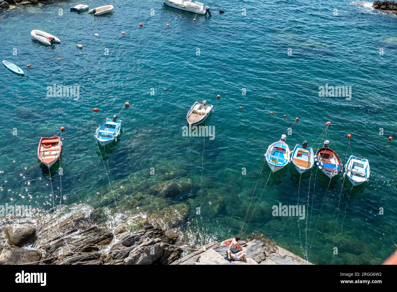 In Riomaggiore befindet sich ein kleiner Hafen mit angelegten Fischerbooten, eines der kleinen Fischerdörfer, die von Klippen hängen, viele mit pastellfarbenen Gebäuden sind Teil von C. Stockfoto
