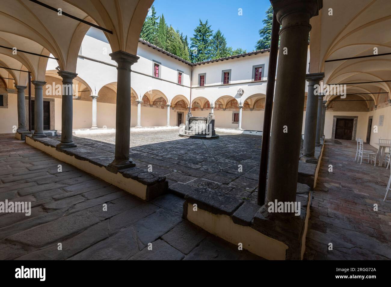 Die umliegenden Klöster mit verblassten Wandmalereien, die vom lokalen Künstler Stefano Lemmi gemalt wurden, und ein zentraler Brunnen im Innenhof des restaurierten Convento del Ca Stockfoto