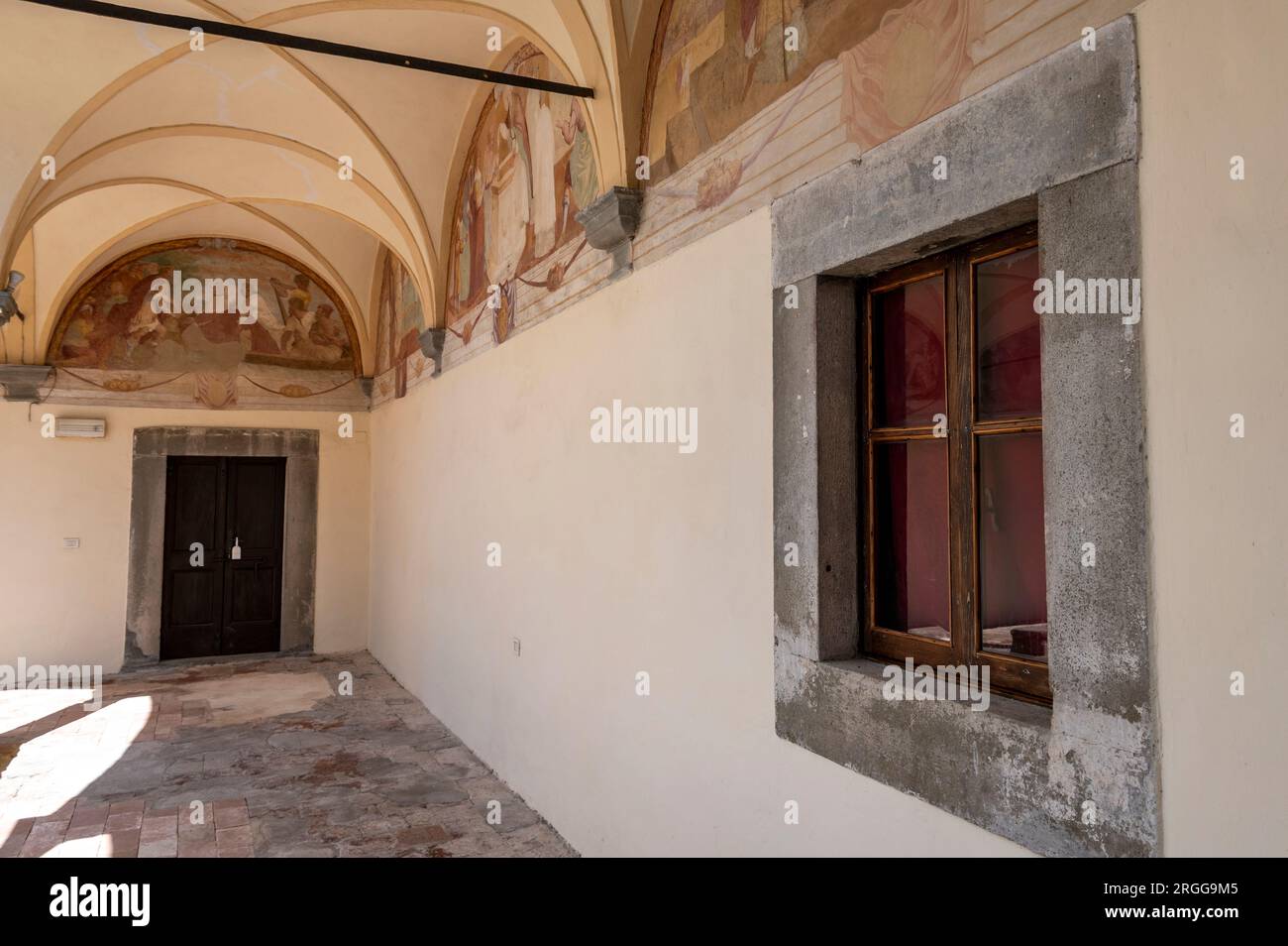 Die umliegenden Klöster mit verblassten Wandmalereien, die vom lokalen Künstler Stefano Lemmi gemalt wurden, und ein zentraler Brunnen im Innenhof des restaurierten Convento del Ca Stockfoto