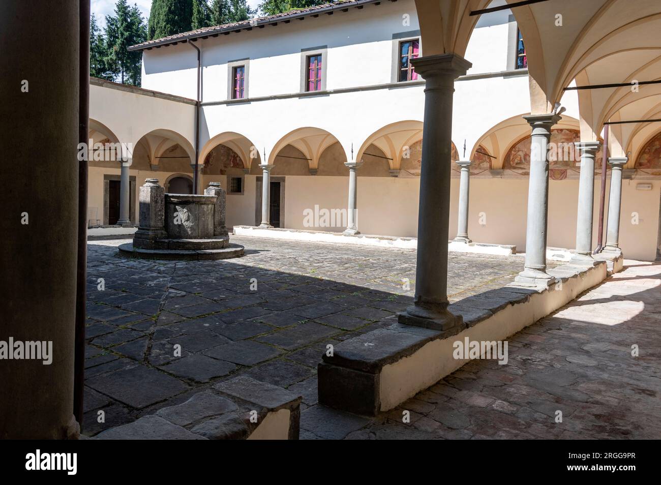 Die umliegenden Klöster mit verblassten Wandmalereien, die vom lokalen Künstler Stefano Lemmi gemalt wurden, und ein zentraler Brunnen im Innenhof des restaurierten Convento del Ca Stockfoto