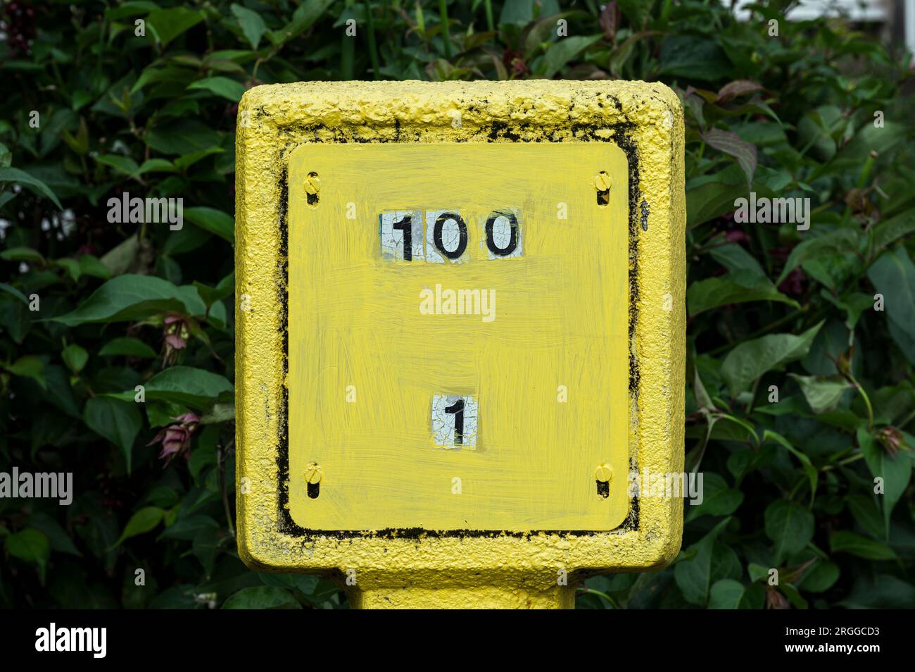 Nummer 1 bis 100 auf einem gelben Hydrantenschild Stockfoto