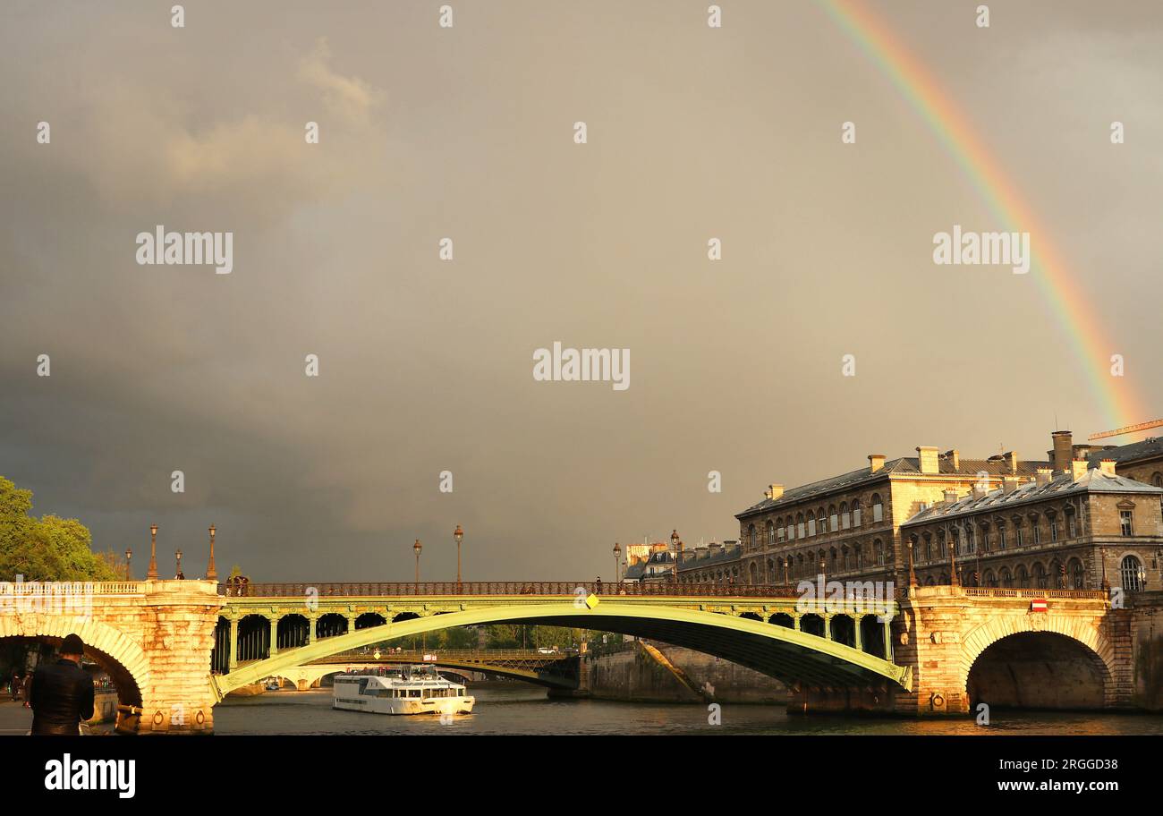 Das grüne Metall der Pont Notre Dame, die die seine in Paris überquert, leuchtet nach starkem Regen im frühen Abendlicht unter einem schwachen Regenbogen Stockfoto Das grüne Metall der Pont Notre Dame, die die seine in Paris überquert, leuchtet nach starkem Regen im frühen Abendlicht unter einem schwachen Regenbogen Stockfoto