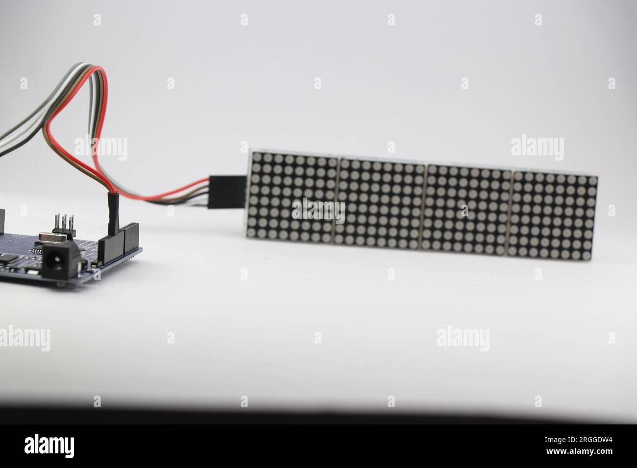 Selbstgebautes Elektronikprojekt, das zeigt, dass die Mikrocontroller-Platine über Jumperdrähte mit einer LED-Punktmatrix-Anzeigetafel verbunden ist Stockfoto