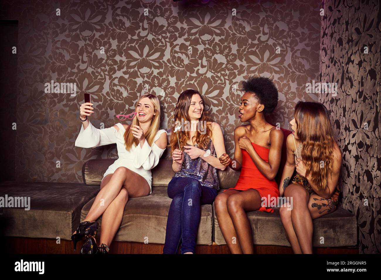 Freunde von selfie auf Sofa bei Nachtclub Stockfoto