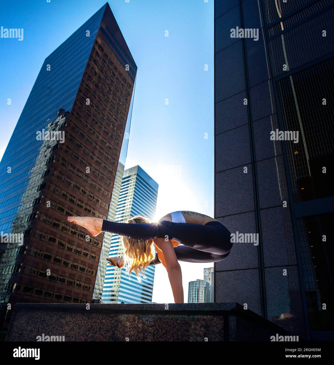 Eine Person, die Yoga in einer Stadtlandschaft in der Dämmerung praktiziert. Stockfoto