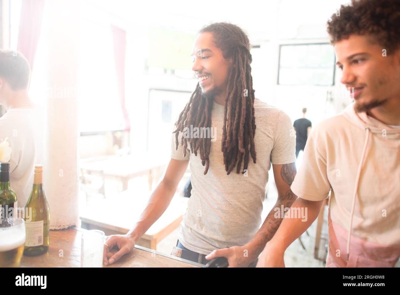 Zwei Männer lächeln an einer Bar. Stockfoto