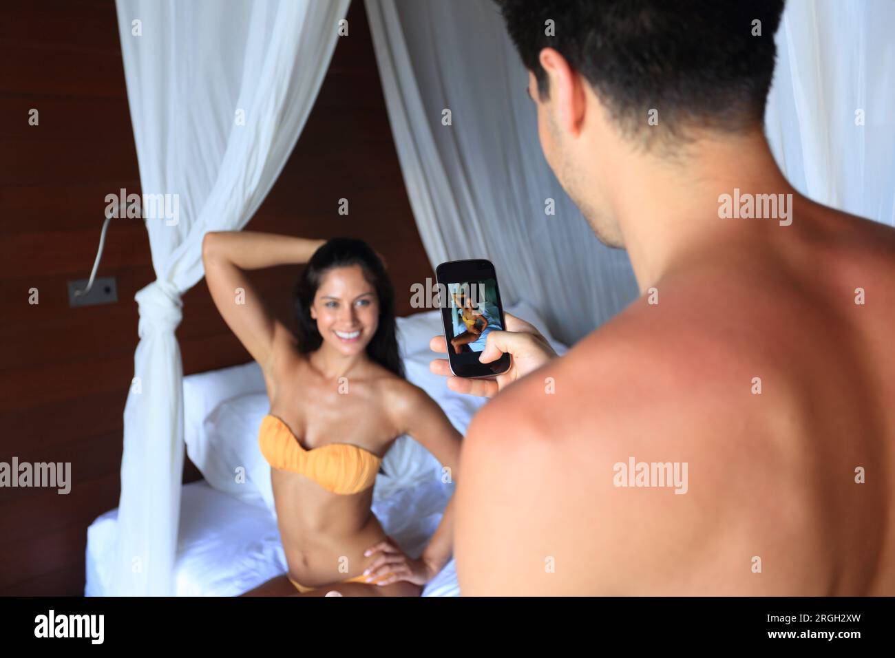 Junger Mann fotografieren junge Frau in Bikini Stockfoto