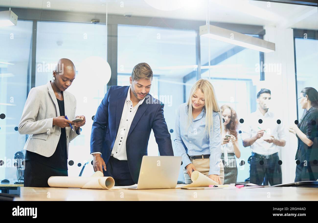 Geschäftsleute, die sich ein Notebook im Konferenzraum ansehen Stockfoto