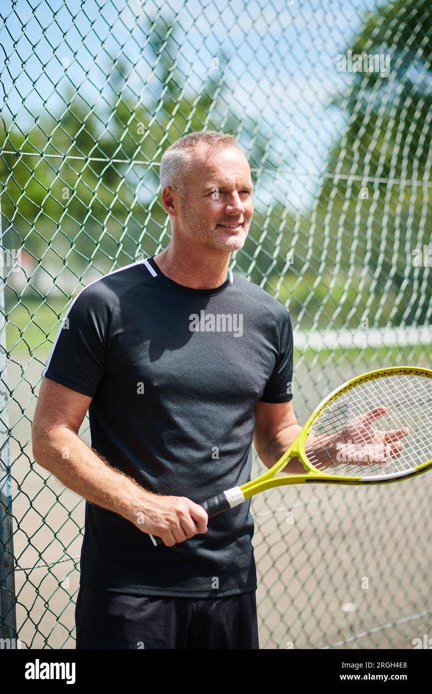 Reifer Mann mit Tennisschläger Stockfoto