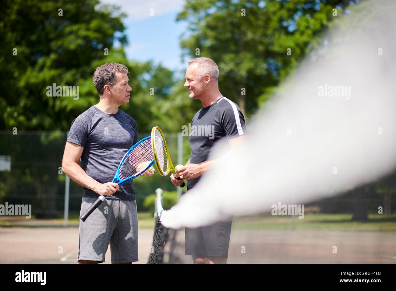 Reife Männer auf dem Tennisplatz Stockfoto