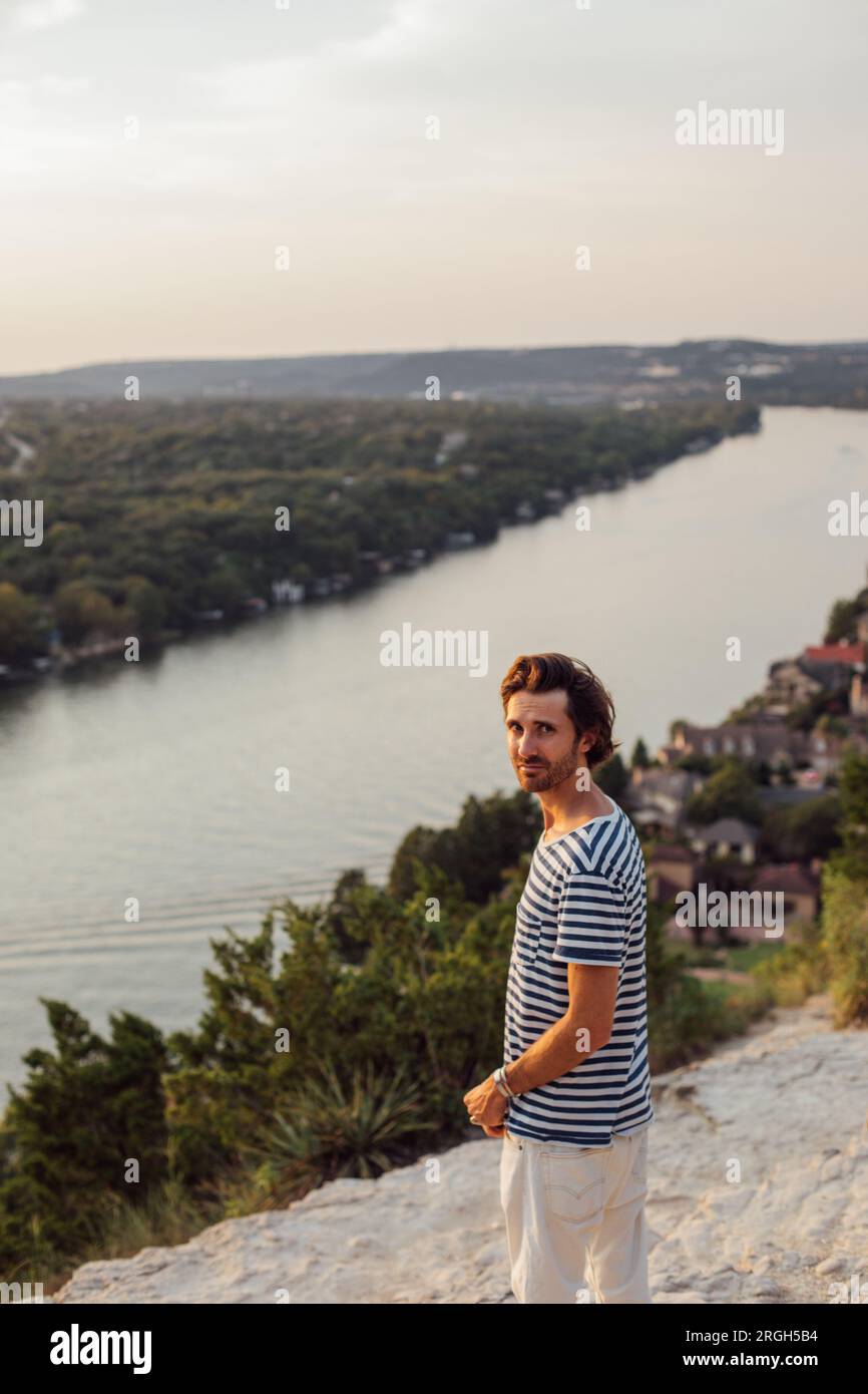 Ein Mann mit gestreiftem Hemd über dem Fluss Stockfoto