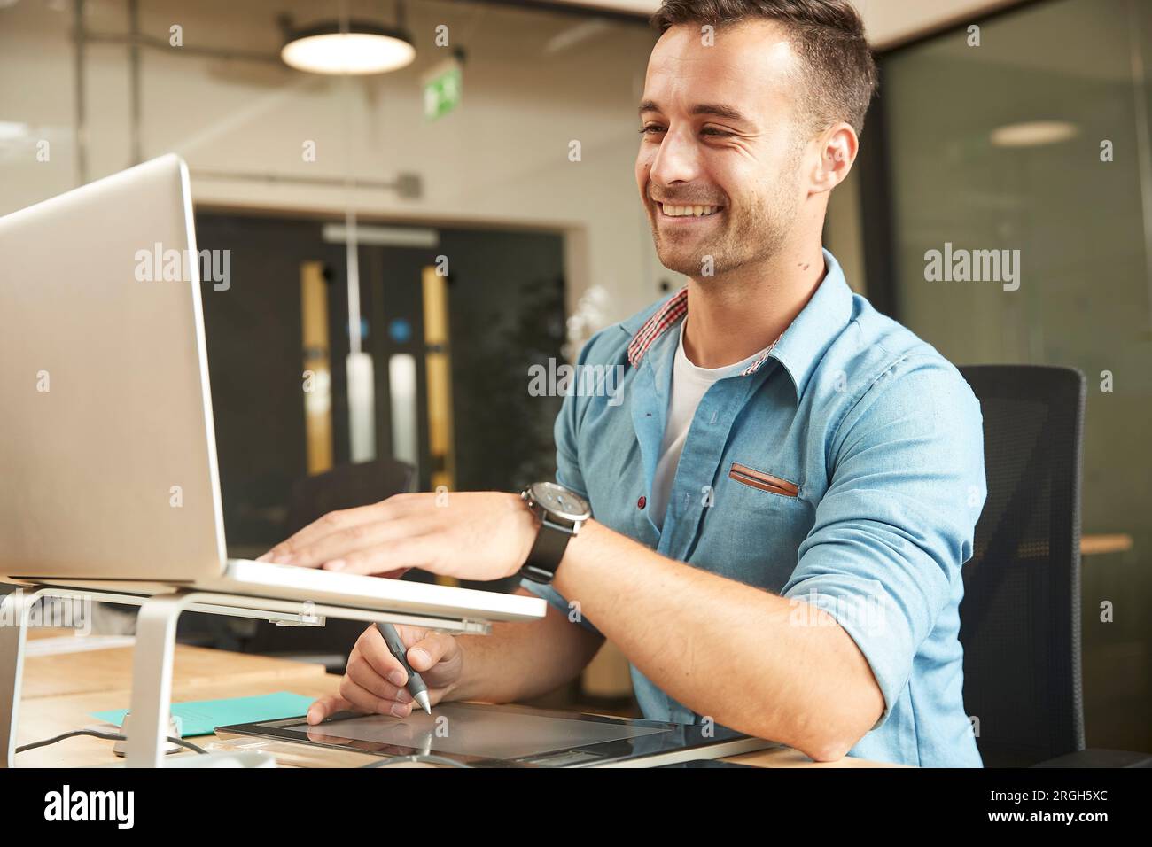Lächelnder junge Mann auf laptop Stockfoto