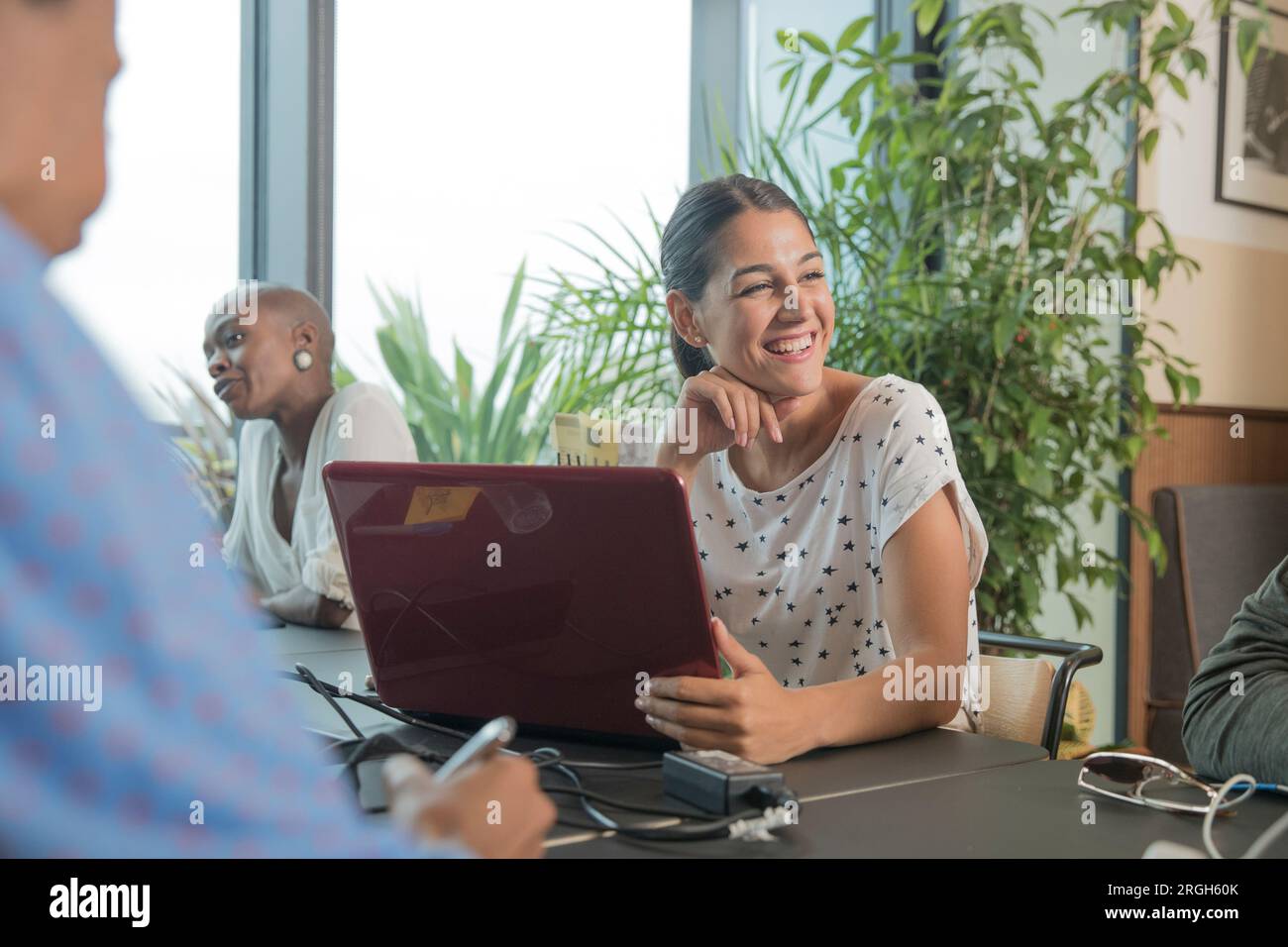 Junge Frau mit Laptop während der Konferenz Stockfoto