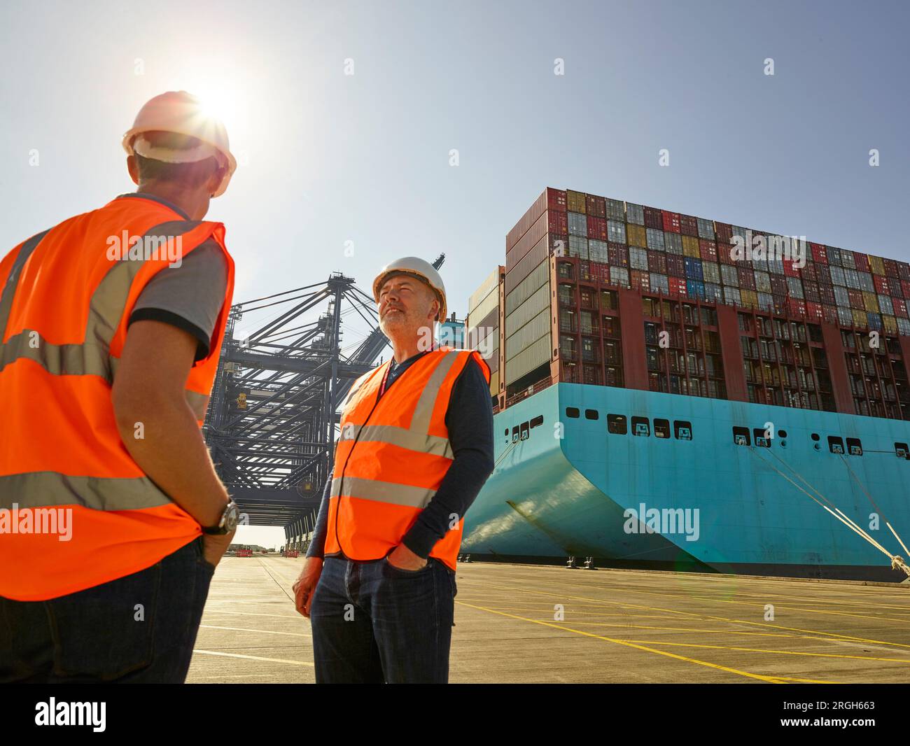 Hafenarbeiter durch Frachter im Hafen von Felixstowe, England Stockfoto