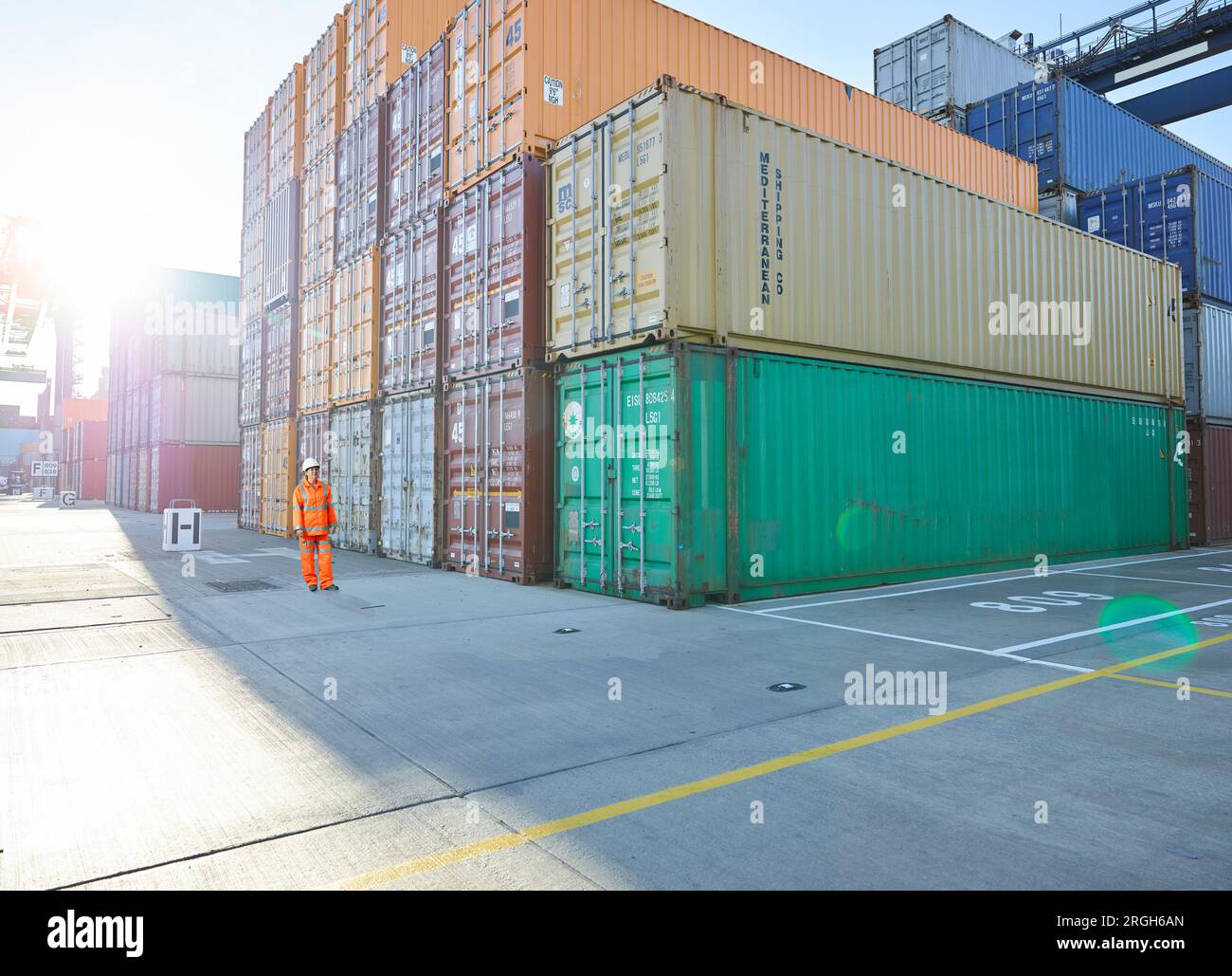 Hafenarbeiter durch Stapel von Cargo Container im Hafen von Felixstowe, England Stockfoto
