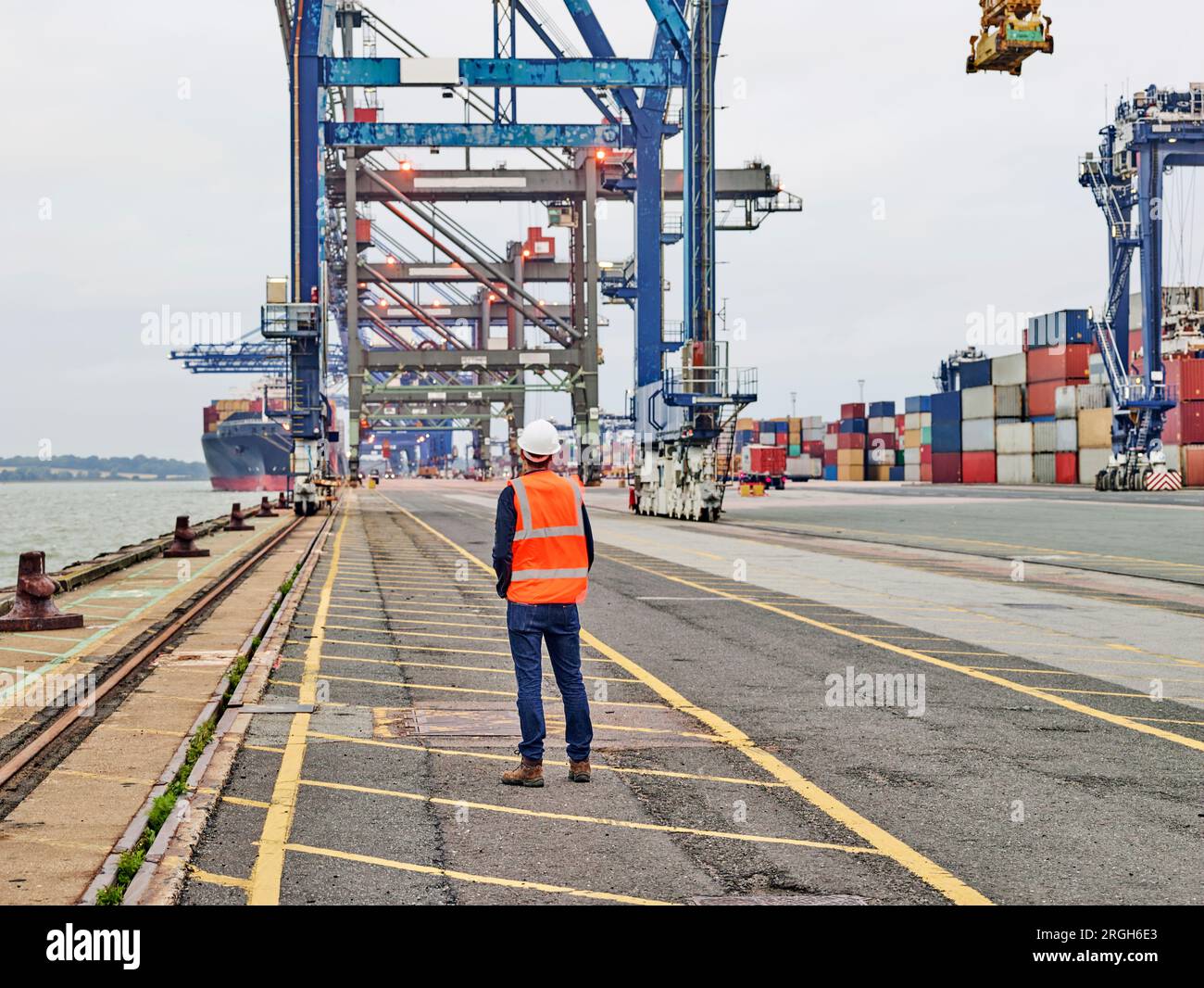 Rückansicht der Hafenarbeiter an der Kräne am Hafen von Felixstowe, England suchen Stockfoto