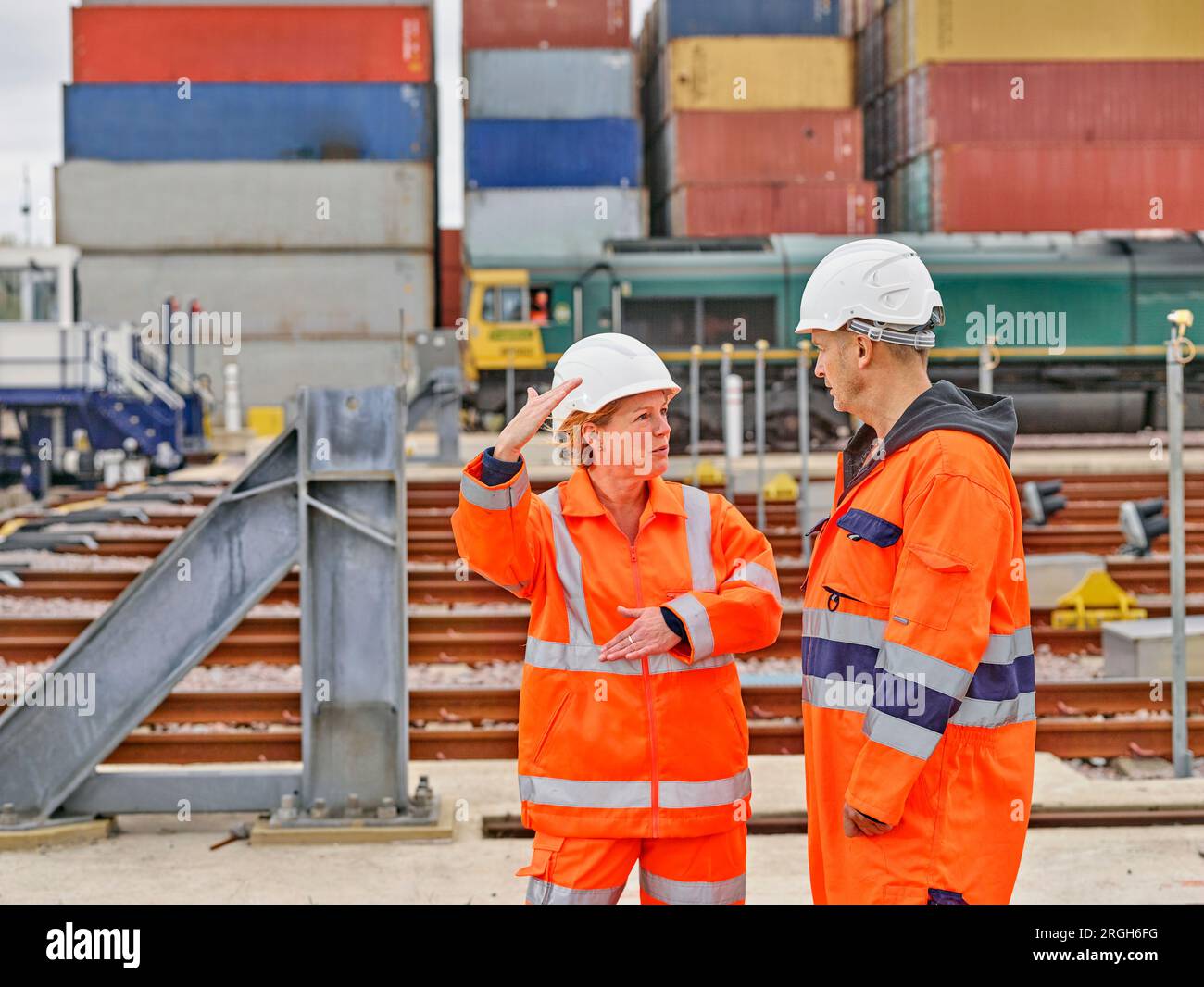 Hafenarbeiter sprechen durch Eisenbahnschienen Stockfoto