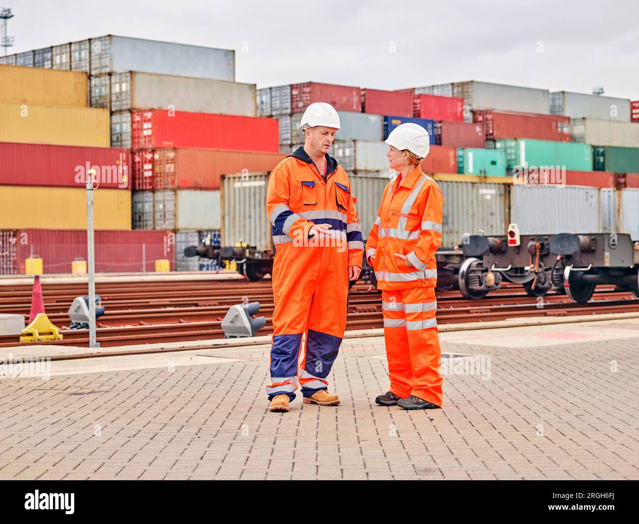 Hafenarbeiter sprechen durch Eisenbahnschienen Stockfoto
