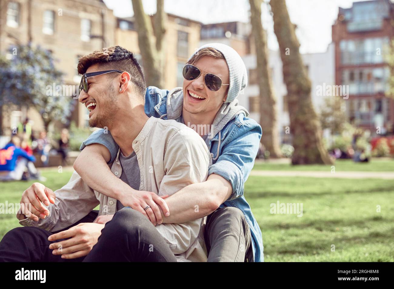 Gay Teenager Paar zusammen sitzt im Park Stockfoto