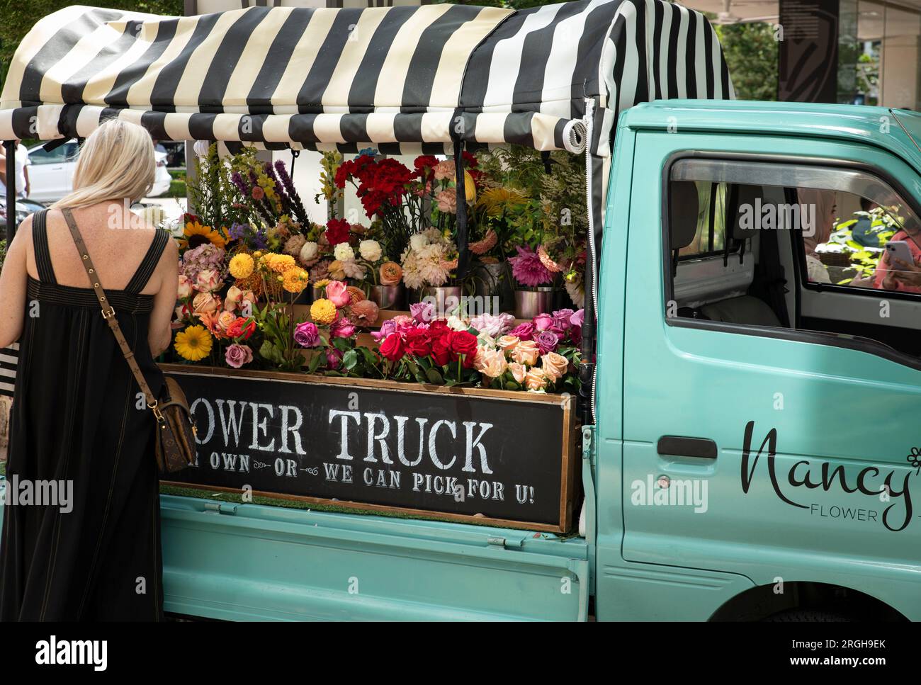 Charmanter Blumenwagen mit frischen Schnittblumen. Stockfoto