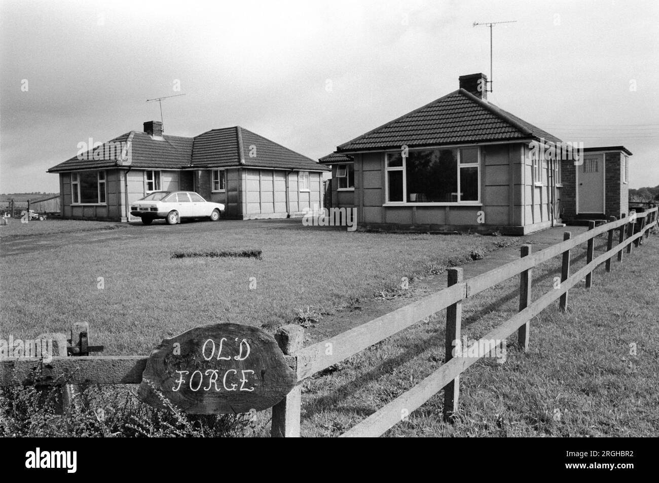 Nachkriegsbungalows UK 1980s Wohngebäude, wo früher die Old Forge lag. Upper Basildon Berkshire. England 1983 HOMER SUKES Stockfoto