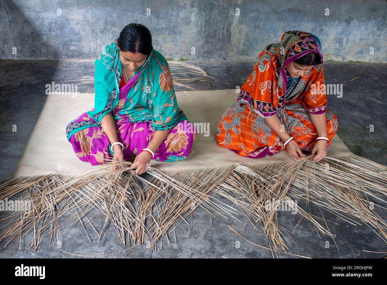 In ihrem Zuhause im Dorf Hailakathi in Rajapur upazila, dem Dorf Jhalakathi, weben Frauen traditionelle Sit-Verstecke (coole Matte). Jhalakathi, Bangladesch Stockfoto