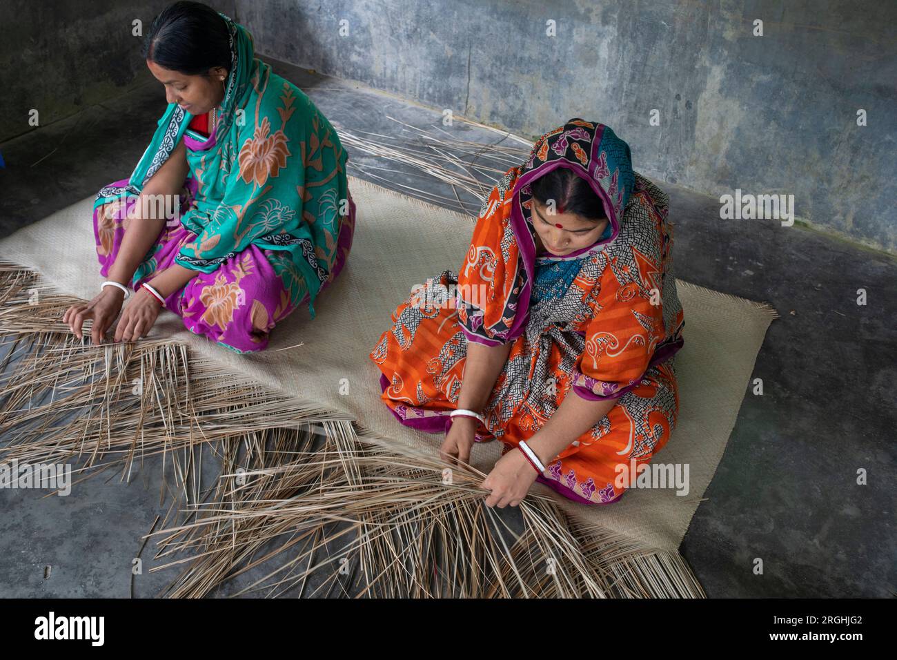 In ihrem Zuhause im Dorf Hailakathi in Rajapur upazila, dem Dorf Jhalakathi, weben Frauen traditionelle Sit-Verstecke (coole Matte). Jhalakathi, Bangladesch Stockfoto