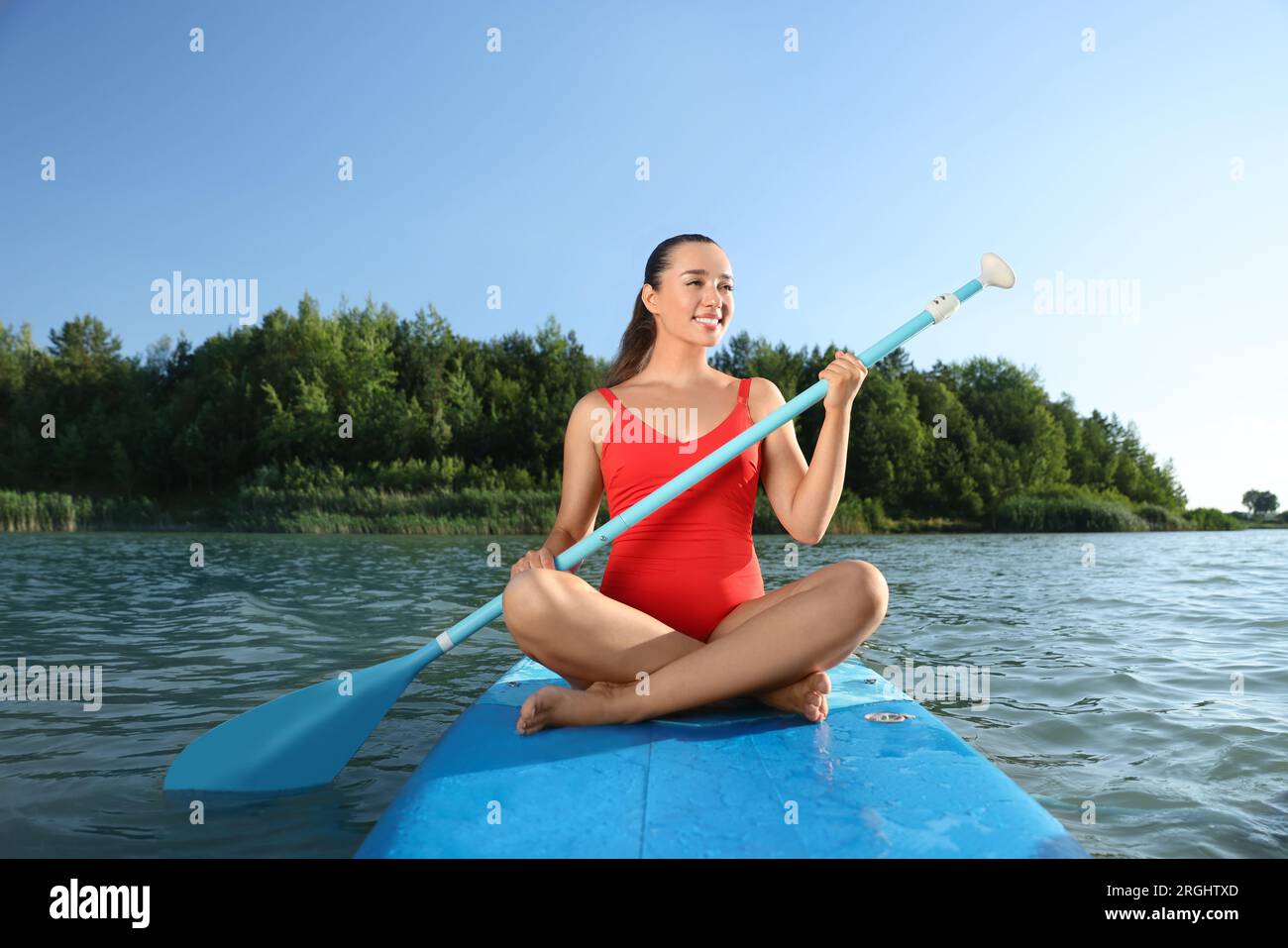Frau paddelt auf dem SUP-Brett im Fluss Stockfoto
