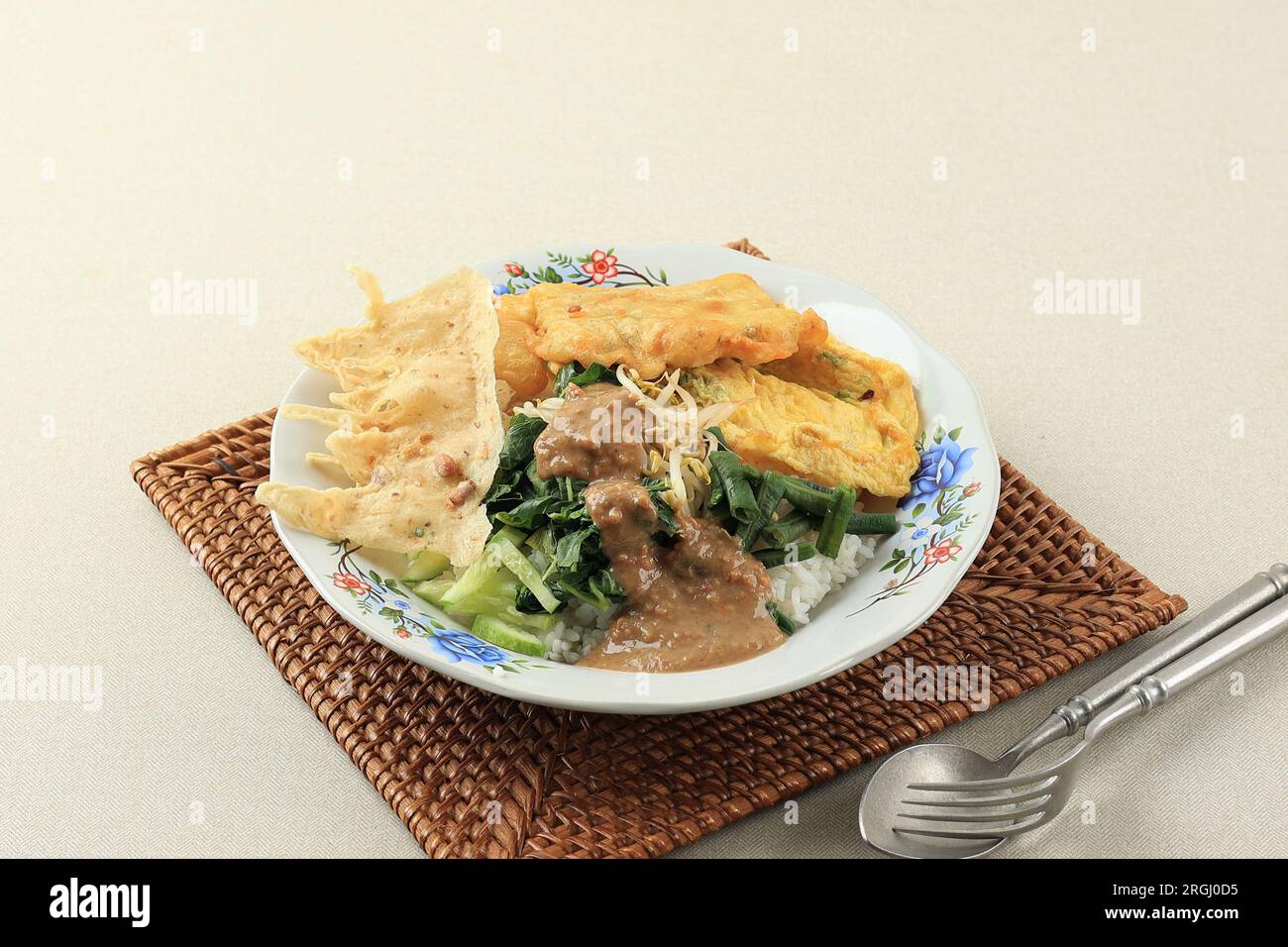 Nasi Pecel Madiun, traditionelles indonesisches Menü mit scharfer Erdnusssoße, Tempeh, gekochtem Gemüse, Rempeyek. Beliebt zum Frühstück, Abendessen oder Mittagessen Stockfoto